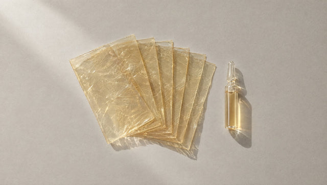 Seven sheets of leaf gelatin fanned out beside a small glass ampoule