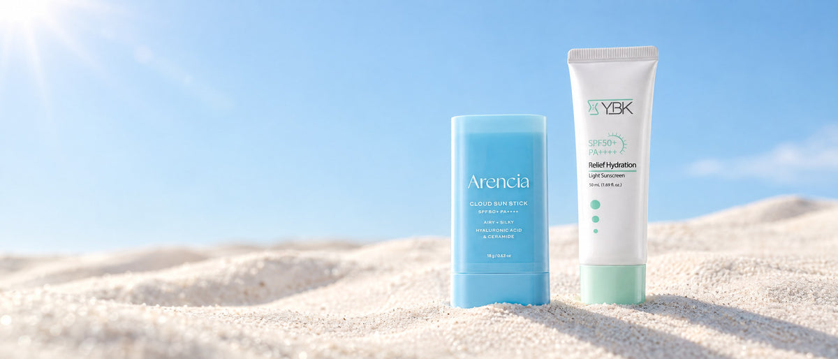 Arencia sun stick and YBK sunscreen, Hwahae award winners, on a sunlit dune